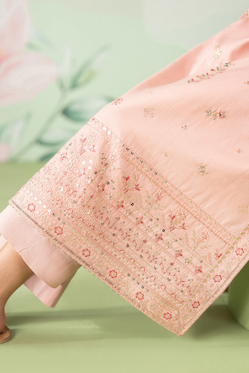 Close-up of a pink embroidered fabric on a green background